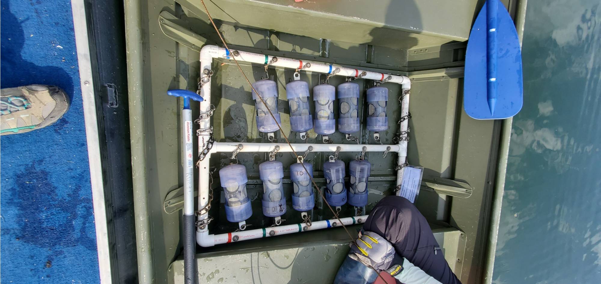 A PVC frame with rows of individual screen-lined cannisters that will allow ambient lake water to mix with the microplastics contained therein.